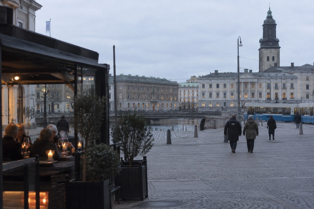 Diners at a candlelit table raising wine glasses in a small Nordic restaurant