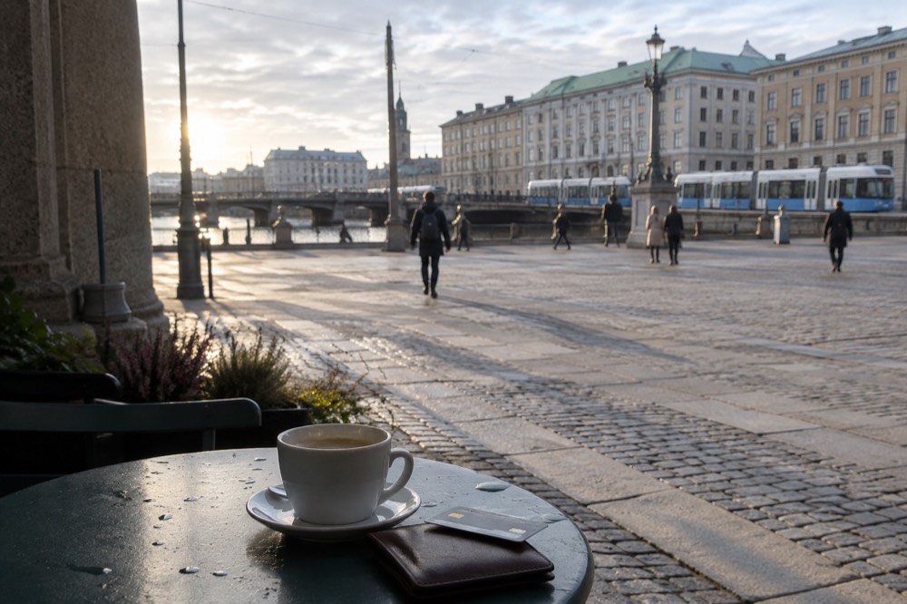 A wallet with a payment card resting on a map of Gothenburg at a cafe table