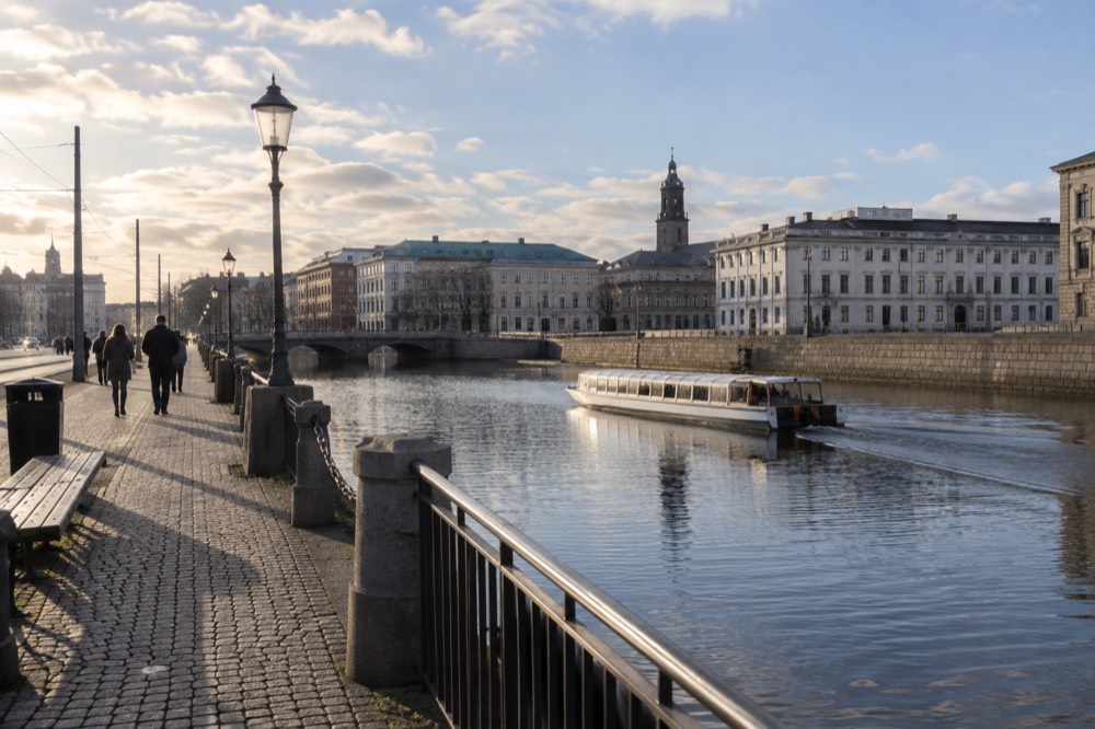 A tour boat on a calm canal under a bright spring sky in central Gothenburg