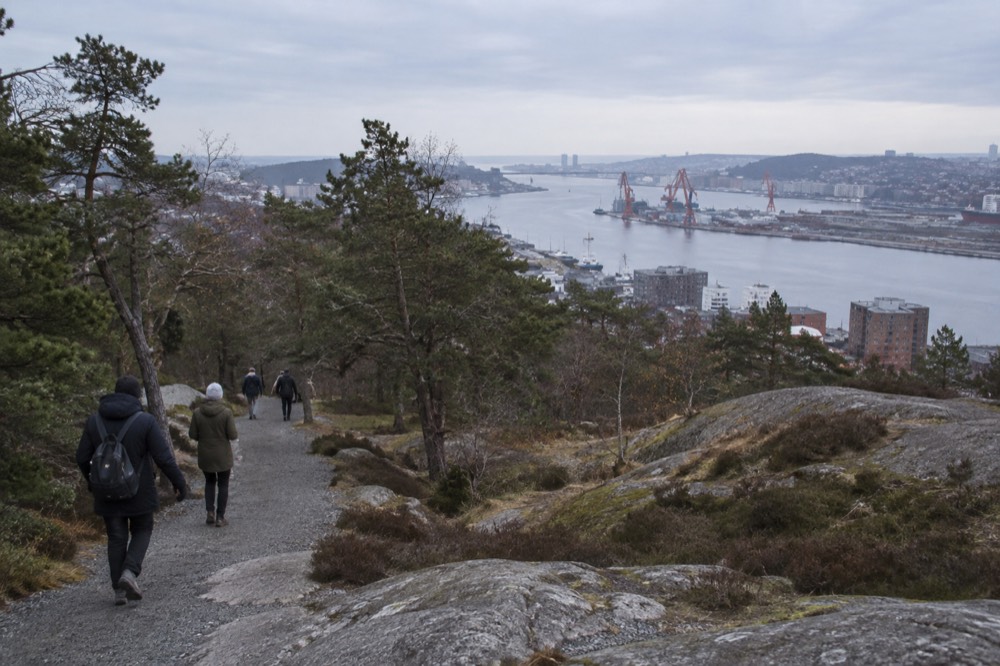 People walking on a gravel path through trees on the slopes of Ramberget