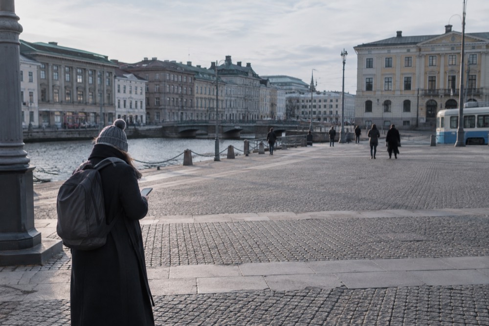 A visitor checking a phone map outside a tram stop in central Gothenburg