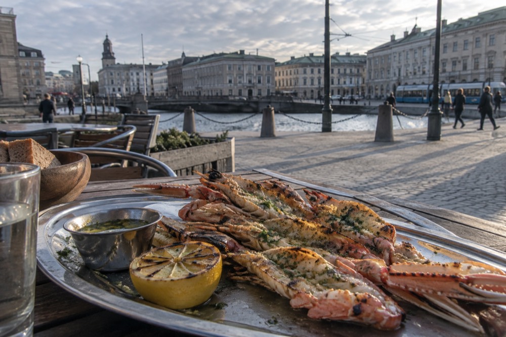 Grilled langoustine with garlic butter and lemon on a metal serving tray