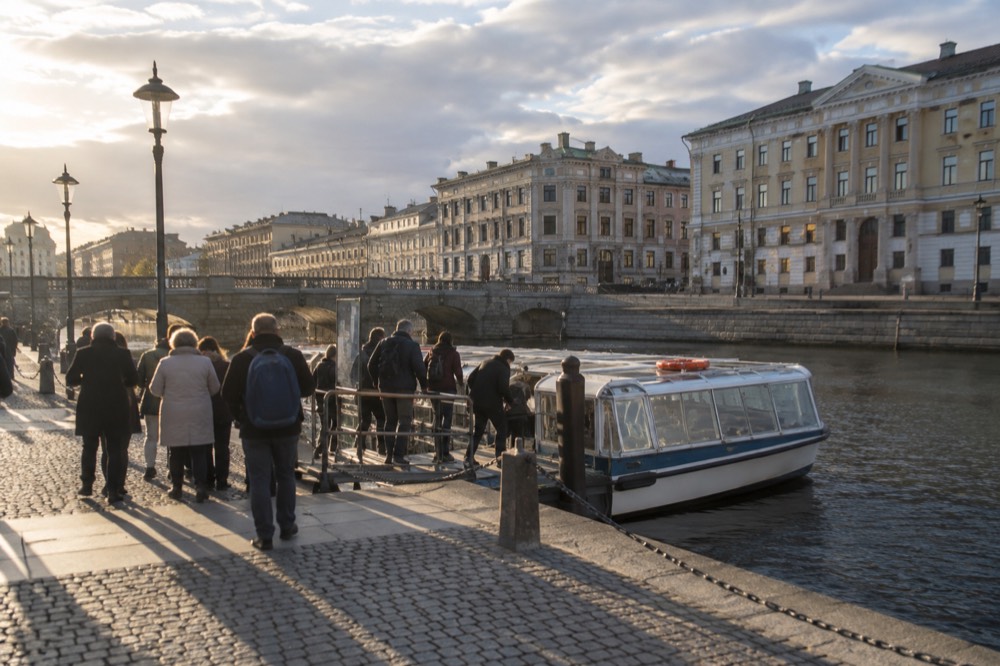 Tourists boarding a sightseeing boat at a canal jetty in central Gothenburg