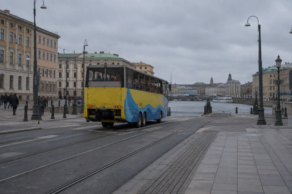 An amphibious sightseeing bus driving down a Gothenburg street towards the river