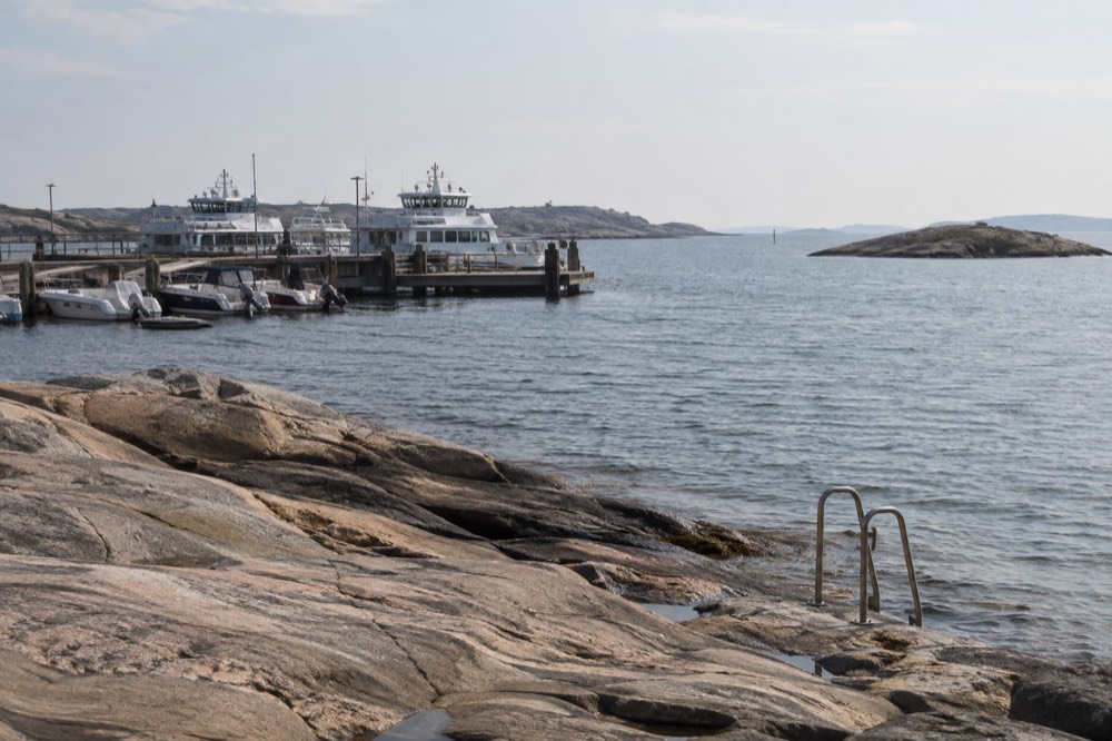Smooth granite rocks at the edge of clear sea, with a swim ladder fixed to the rock
