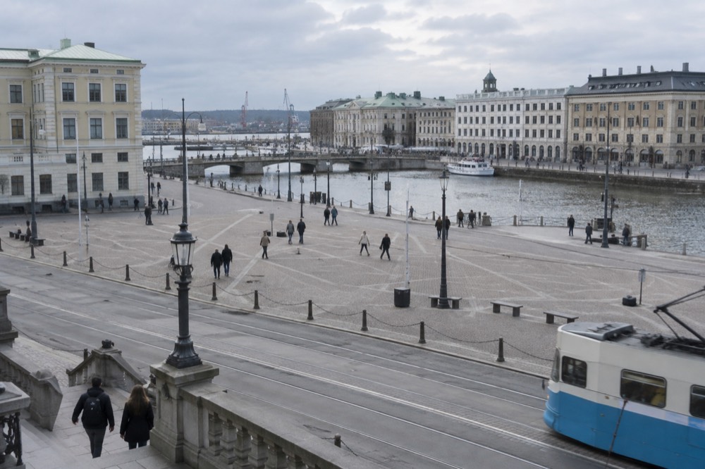 A packed suitcase with rain jacket and warm layers open in a Gothenburg hotel room
