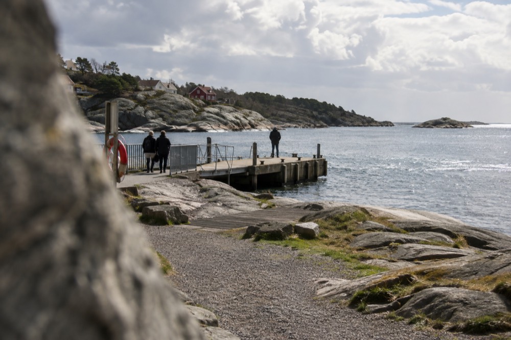 Smooth granite rocks along the Brännö shoreline with calm sea and a distant island