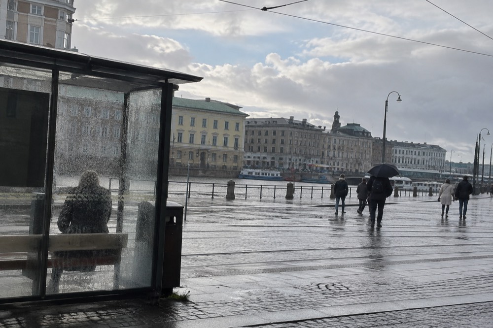 Rain streaking down the windows of a Gothenburg tram stop shelter