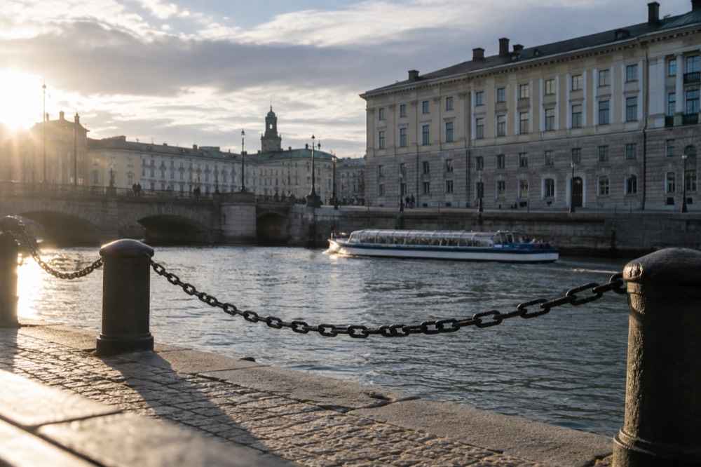 Gothenburg canal in morning light with a sightseeing boat passing old stone buildings
